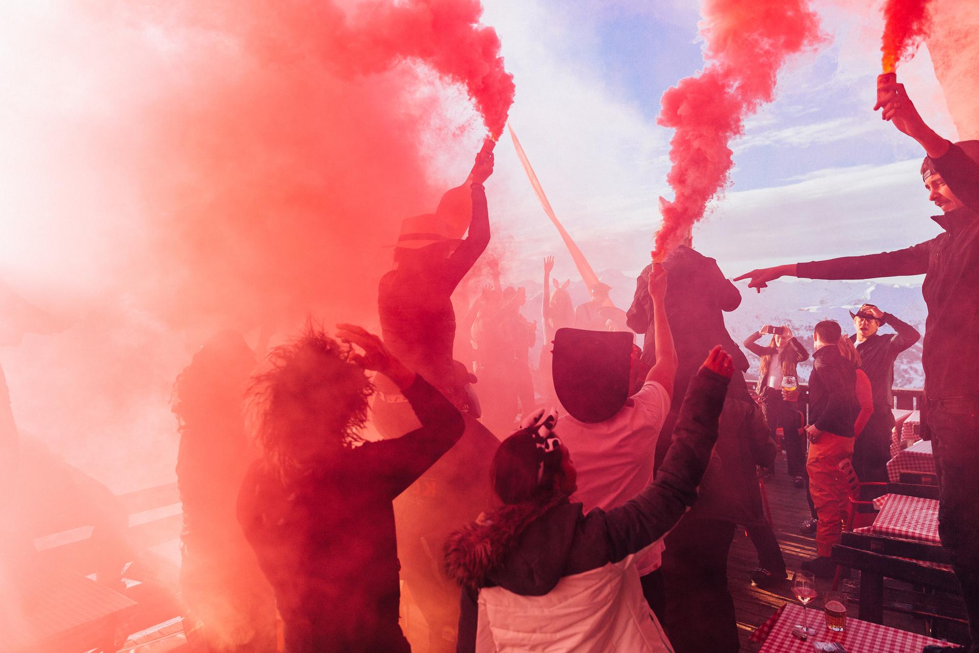 Apres ski party goers setting off flare at bar